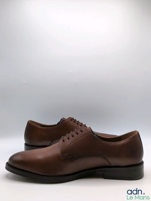 une paire de chaussures marron sur fond blanc
