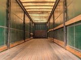an image of a long hallway with green walls and wood flooring