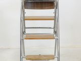 an image of a metal and wood step stool against a white wall