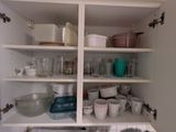 de nombreux plats et tasses sur les étagères de la cuisine