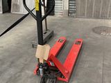 a red fork lifter sitting on the concrete floor