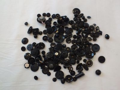 un tas de boutons noirs sur une surface blanche