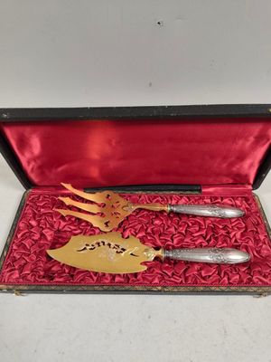 une boîte rouge contenant deux couteaux et une cuillère