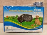 an electronic fence system with a dog sitting on the grass