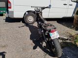 a motorcycle parked in front of a van in a parking lot