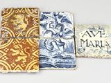 quatre sous-verres aux motifs variés posés sur une surface blanche