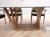 a glass table with a wooden base and chairs around it