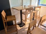 des tables et des chaises dans une pièce dotée d'une fenêtre et d'un parquet
