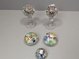 quatre boutons en verre aux motifs variés, posés sur une table