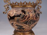 a vase that has a dragon on it on a stand
