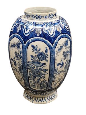 a blue and white vase with a bird and flowers on it