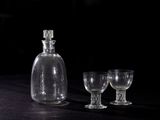 two empty wine glasses and a decanter on a table