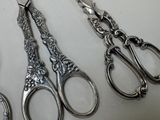 three pairs of silver scissors sitting next to each other on a table
