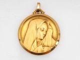 a close up of a gold medal with a woman in a veil