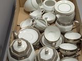 une boîte remplie d'assiettes et de tasses blanches et argentées