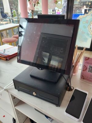 une petite caisse enregistreuse pos posée sur une table devant une fenêtre