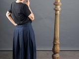 a woman that is standing next to a tall vase