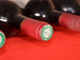 several bottles of wine are lined up on a red table