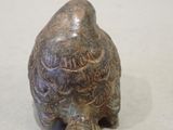 a small figurine of a bird sitting on a table