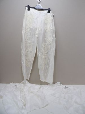 un pantalon blanc suspendu à un cintre accroché au mur