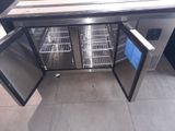 a stainless steel counter top with two doors open