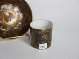 une petite tasse et une soucoupe posées sur une table