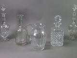 five glass vases and a glass bottle on a table