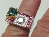 la main d'une femme tenant une bague sertie d'un diamant et d'une émeraude