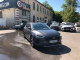 the grey car is parked in front of a large building