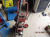 a small hand truck with a hose attached to it in a garage