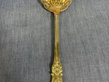 une cuillère en or ornée d'une fleur, posée sur une table