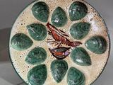 une assiette verte avec un oiseau dessiné dessus, posée sur une table