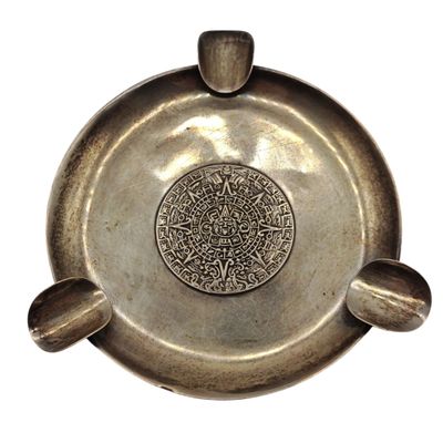 une assiette en argent ornée d'un motif sur fond blanc