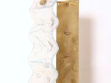 une sculpture blanche et dorée posée sur une table blanche