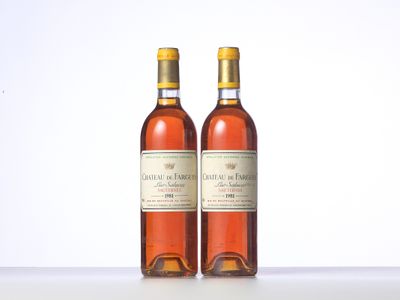 two bottles of wine sitting on top of a table next to each other