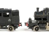 two toy trains sitting side by side on a white surface