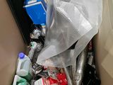 a trash can filled with various items in a box