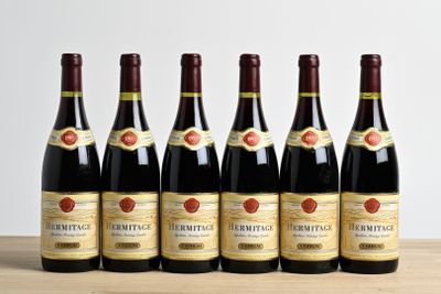 six bottles of wine are lined up on a wooden table