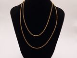 a black mannequin with a gold chain on it