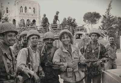 photo en noir et blanc d'un groupe de soldats debout devant un bâtiment
