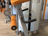 several machines in a gym with a refrigerator in the background