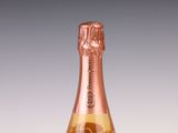 une bouteille de champagne avec une étiquette rose sur fond blanc