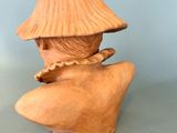 a clay sculpture of a woman with a hat on her head