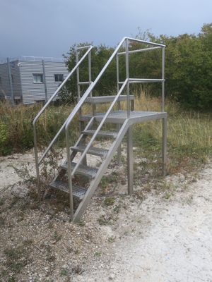 a metal stair going up to the top of a hill