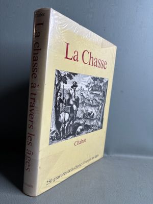 the book la chasse is sitting on a table next to a gray wall