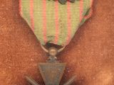 an old military medal with a feather on it on a brown background