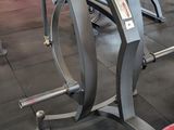 a gym room with a row of stationary exercise machines
