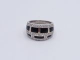 a close up of a ring with black and white stones on it