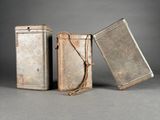 two old metal tins are sitting next to each other on a gray surface