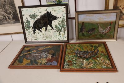 three framed pictures of animals and birds on a table in a room